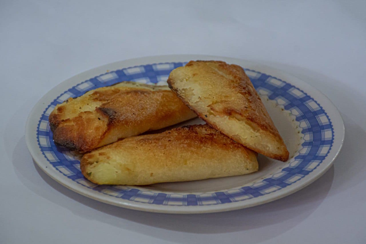 EMPANADAS DE ARROZ: LA EMPANADA DE ARROZ ELABORADA A BASE DE HARINA DE ARROZ Y YUCA HERVIDA  MOLIDA MESCLADA CON MANTEQUILLA Y SAL SE ACOMPAÑA CON UNA TAZA DE CHOCOLATE CALIENTE PARA DESAYUNO O MERIENDA